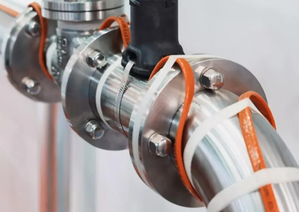 Industrial process piping wrapped securely with heat tracing cable