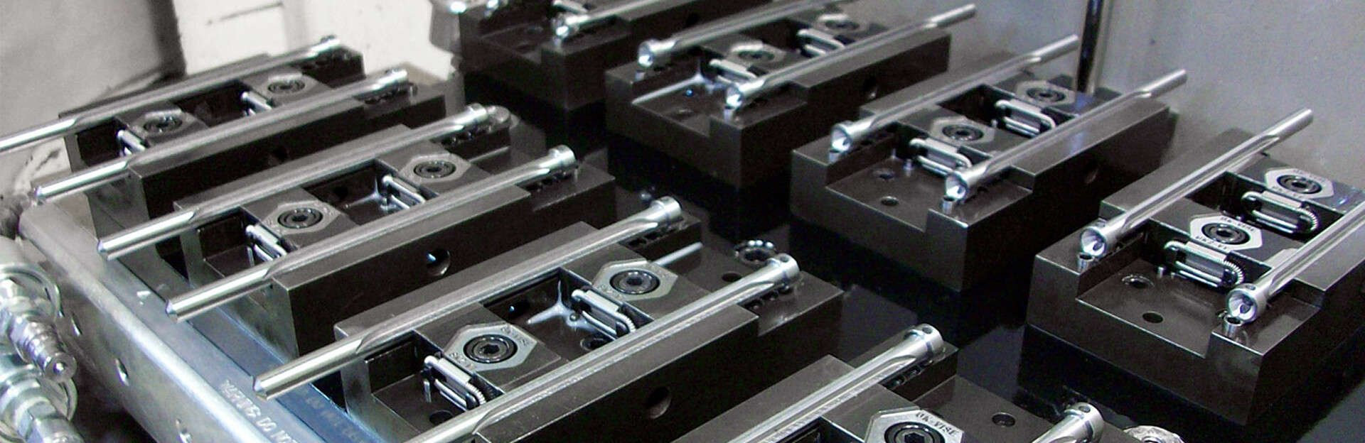Machining fixture with hardened steel locating pins and datum pads machined to tight tolerance
